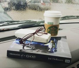 Kim Cameron's artfully arranged book, coffee, and glasses on a rainy day