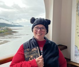 Susan Sheehy with her copy of Eventual Beginnings on her Alaska cruise.