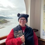 Susan Sheehy with her copy of Eventual Beginnings on her Alaska cruise.